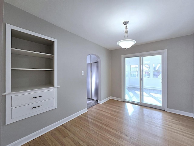 interior space featuring built in shelves and light hardwood / wood-style floors