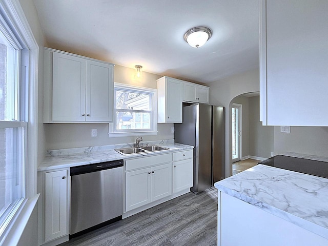 kitchen featuring stainless steel appliances, light hardwood / wood-style floors, sink, and white cabinets