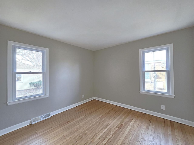 spare room featuring a healthy amount of sunlight and light hardwood / wood-style flooring