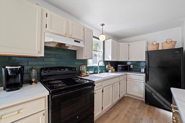 kitchen featuring hanging light fixtures, sink, white cabinets, and black appliances