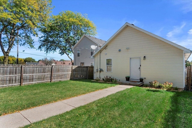 rear view of property featuring a lawn