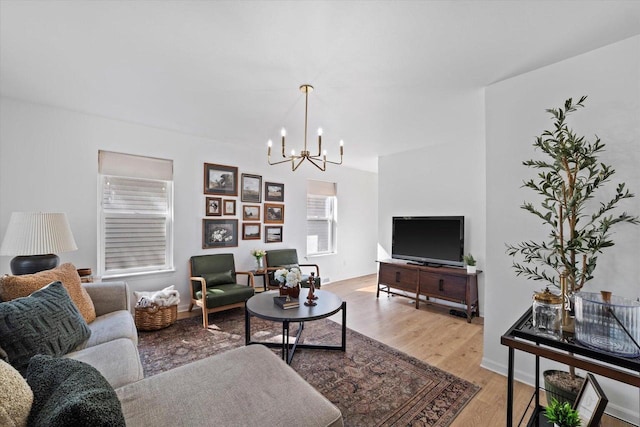 living room with light hardwood / wood-style flooring and a notable chandelier