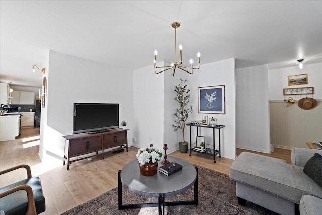 living room with a notable chandelier and light hardwood / wood-style flooring