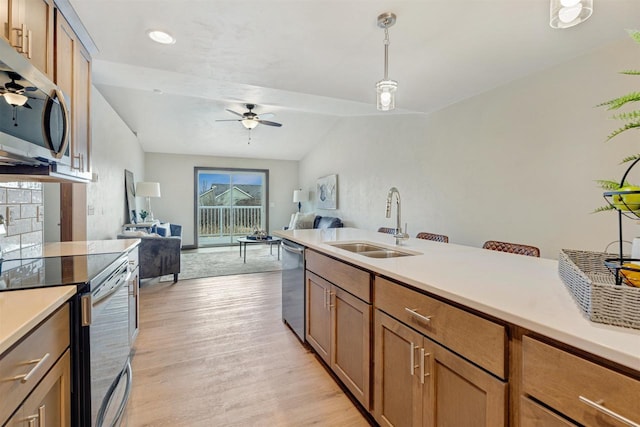 kitchen with sink, hanging light fixtures, light wood-type flooring, ceiling fan, and stainless steel appliances