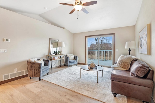 living room with vaulted ceiling, ceiling fan, and light wood-type flooring