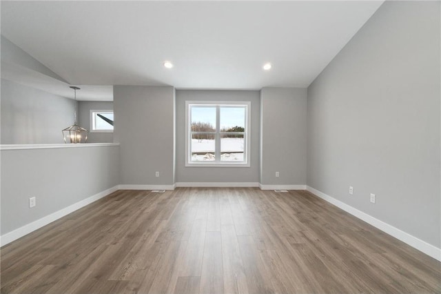 unfurnished room with wood-type flooring and a chandelier