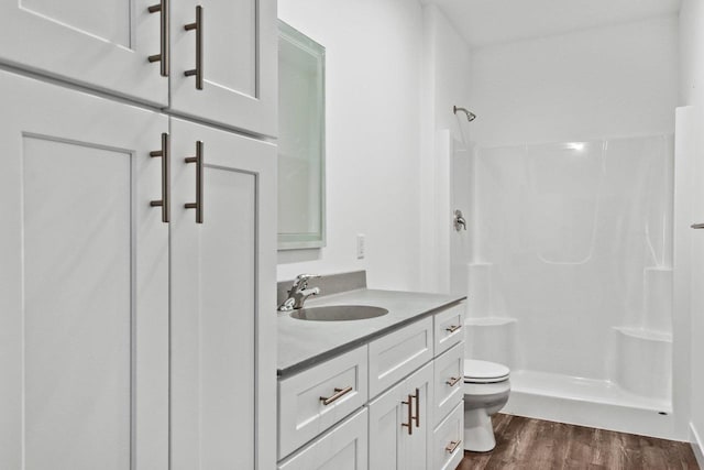 bathroom featuring vanity, toilet, hardwood / wood-style floors, and a shower