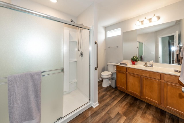 bathroom featuring hardwood / wood-style flooring, vanity, an enclosed shower, and toilet