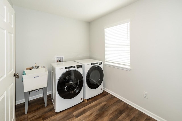 clothes washing area with dark hardwood / wood-style flooring and separate washer and dryer