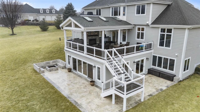 rear view of property with an outdoor fire pit, a yard, a deck, and a patio area