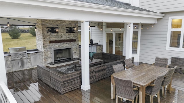 deck featuring area for grilling, a grill, and an outdoor living space with a fireplace