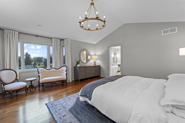 bedroom with lofted ceiling, dark hardwood / wood-style flooring, connected bathroom, and a notable chandelier