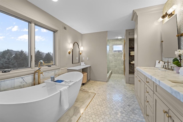 bathroom featuring vanity and independent shower and bath