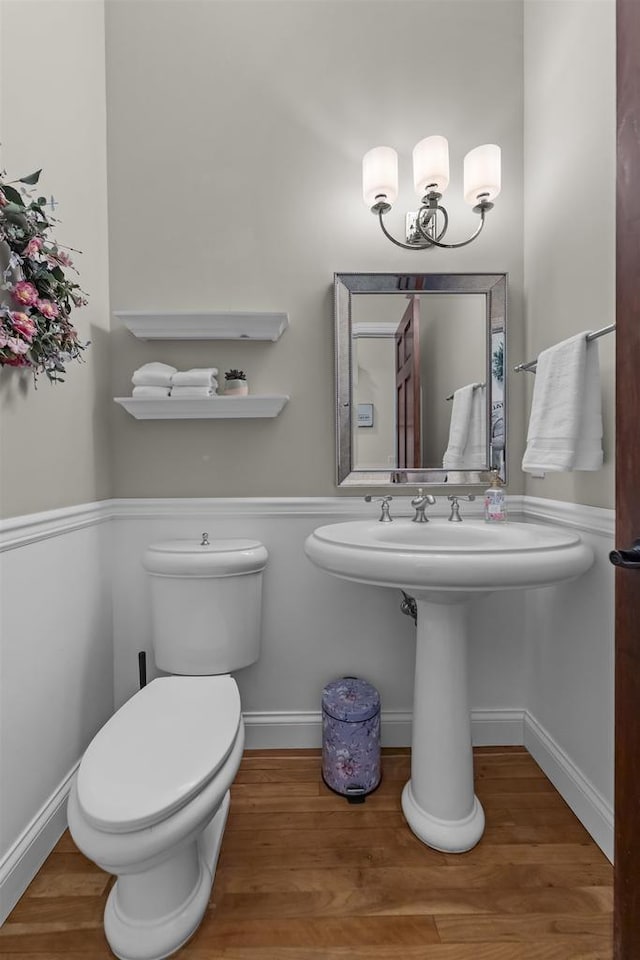 bathroom with an inviting chandelier, toilet, and hardwood / wood-style floors