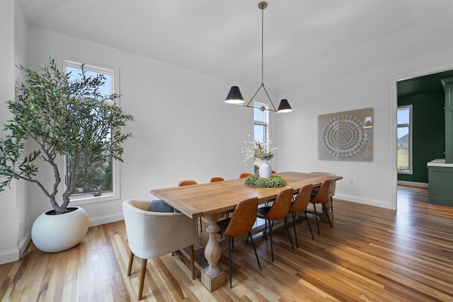 dining space featuring plenty of natural light, hardwood / wood-style floors, and a chandelier