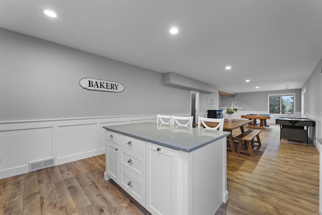 kitchen featuring light hardwood / wood-style flooring, white cabinets, and a kitchen island