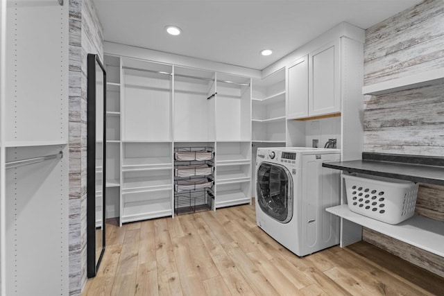 laundry room featuring cabinets, washer / dryer, and light wood-type flooring