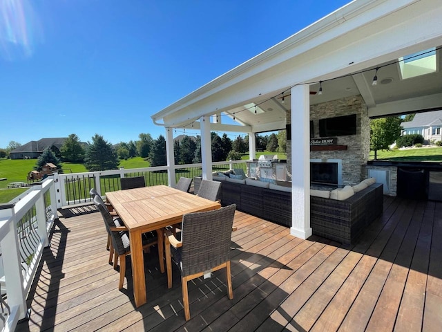 wooden terrace with an outdoor living space with a fireplace