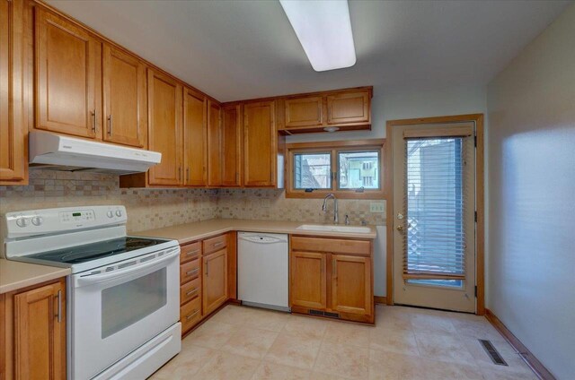 kitchen with tasteful backsplash, sink, and white appliances