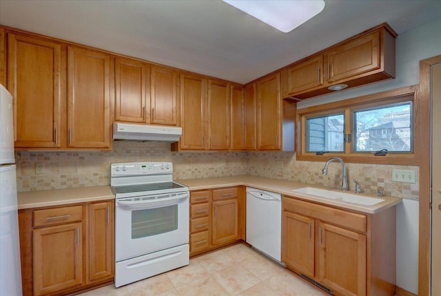 kitchen featuring tasteful backsplash, sink, and white appliances