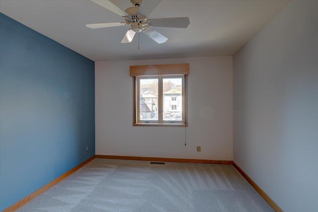 carpeted spare room with ceiling fan