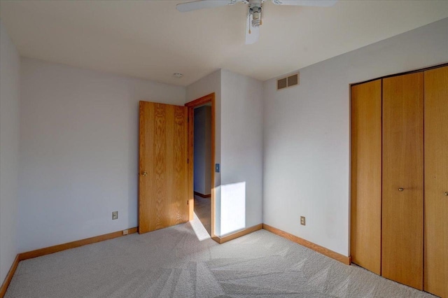 unfurnished bedroom featuring light carpet, a closet, and ceiling fan