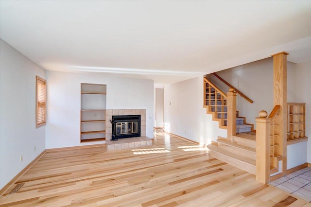 unfurnished living room with hardwood / wood-style floors and a tile fireplace