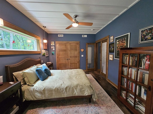 bedroom with dark hardwood / wood-style flooring and ceiling fan