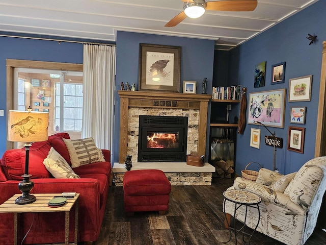 living room featuring a stone fireplace, hardwood / wood-style floors, and ceiling fan