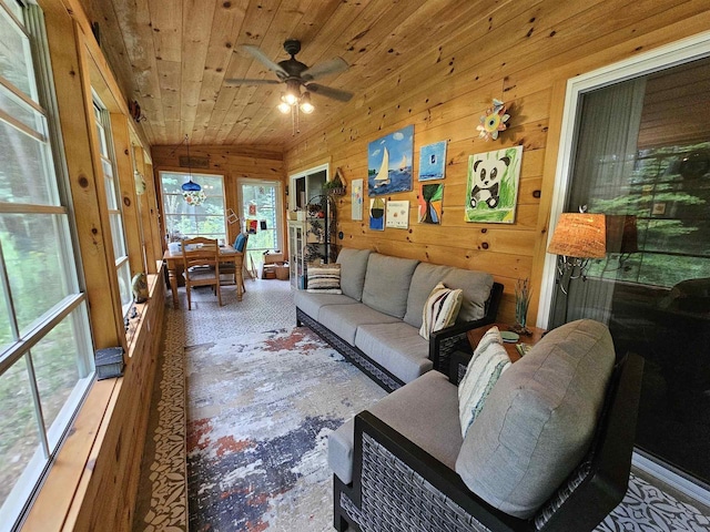 living room with ceiling fan, wooden walls, and wooden ceiling