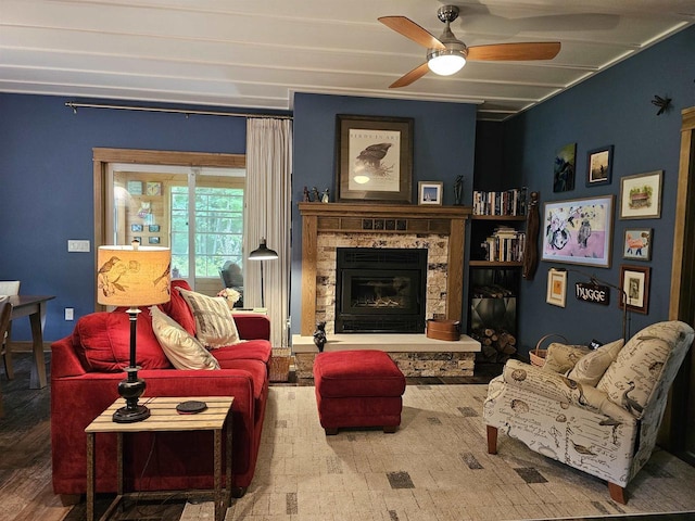 living room with ceiling fan and a stone fireplace