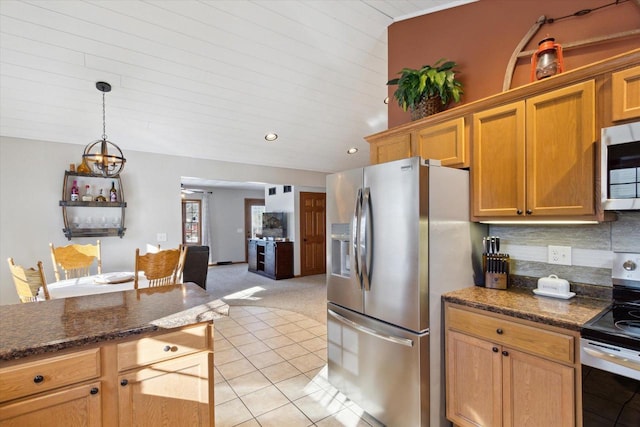 kitchen featuring dark stone countertops, light tile patterned floors, pendant lighting, stainless steel appliances, and backsplash