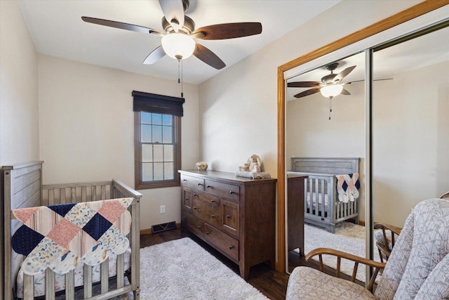 bedroom with ceiling fan, dark hardwood / wood-style flooring, and a closet