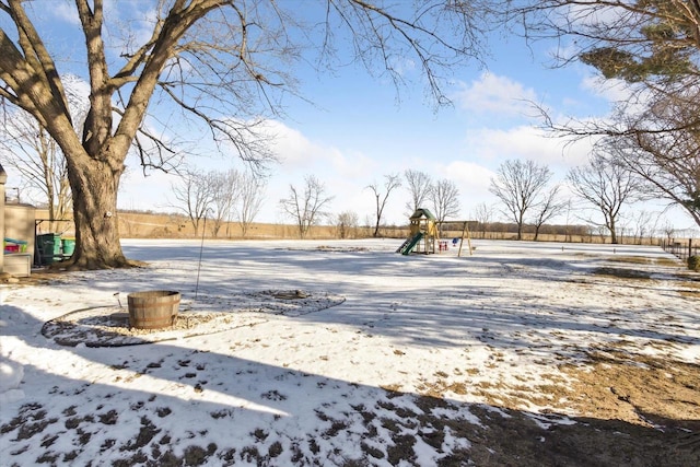 yard layered in snow with a playground