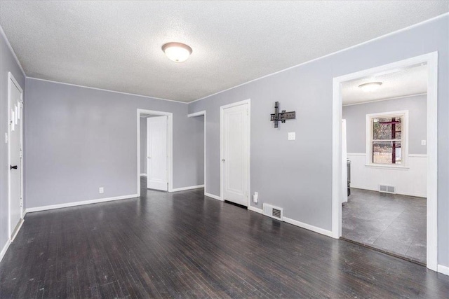 empty room with dark wood-type flooring and a textured ceiling