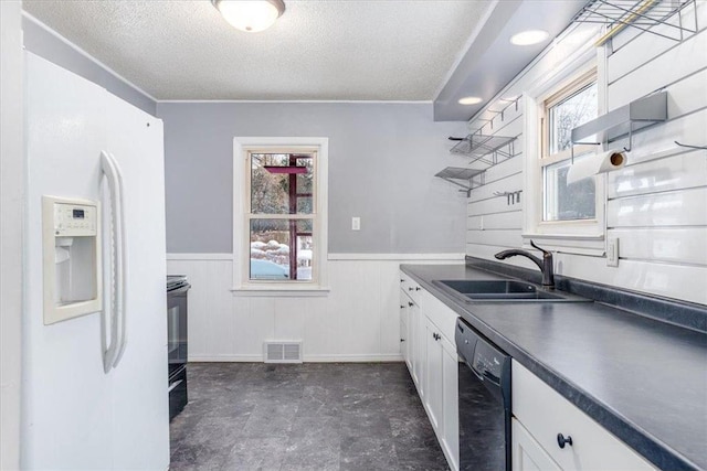 kitchen featuring white cabinetry, black dishwasher, sink, white fridge with ice dispenser, and a healthy amount of sunlight