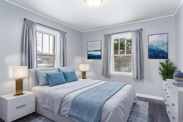 bedroom with dark wood-type flooring, ornamental molding, and a textured ceiling