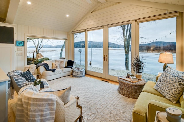 sunroom / solarium featuring a water and mountain view and vaulted ceiling with beams