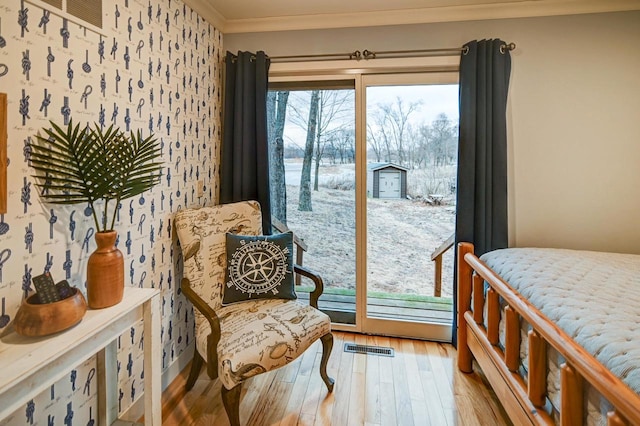 bedroom with hardwood / wood-style flooring, ornamental molding, and access to outside