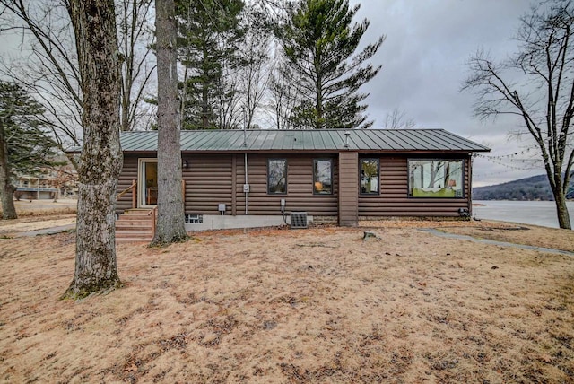 view of front of home featuring a water view and central air condition unit