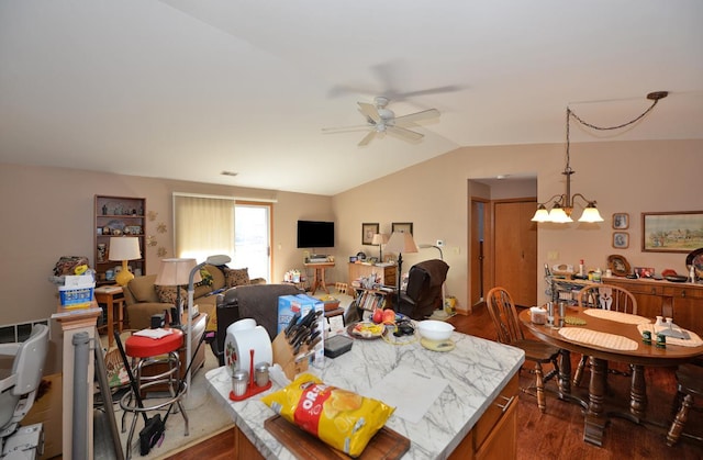 dining room with dark wood-type flooring, ceiling fan with notable chandelier, and vaulted ceiling