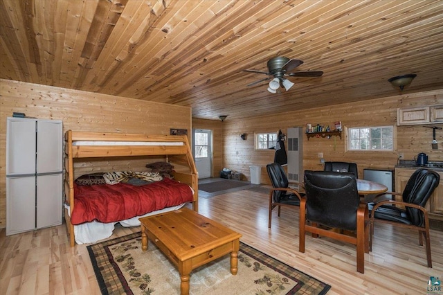 bedroom featuring wooden ceiling, wooden walls, and light wood-type flooring