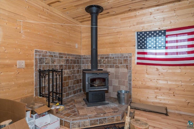 room details featuring a wood stove, wood ceiling, and wooden walls