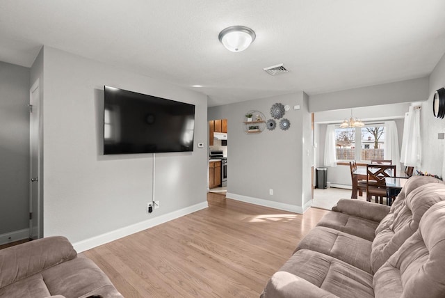 living room with a notable chandelier and light wood-type flooring