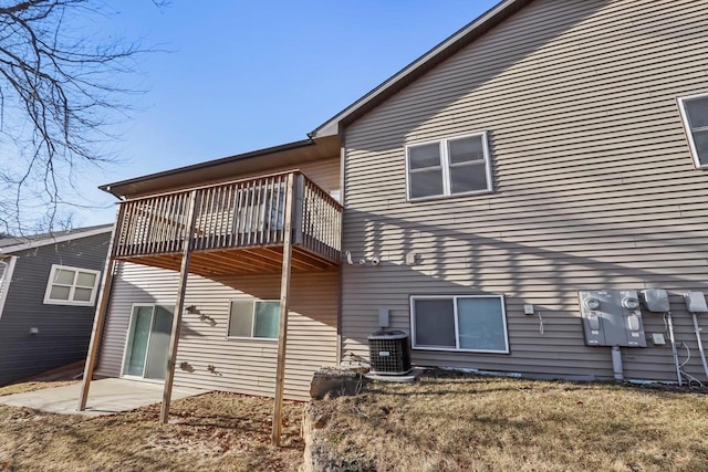 back of property featuring cooling unit, a balcony, a yard, and a patio area