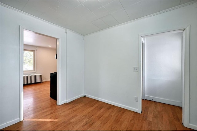 unfurnished room with hardwood / wood-style flooring and radiator