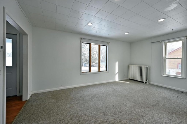 carpeted spare room with radiator heating unit