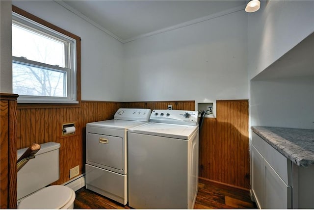 washroom with ornamental molding, washer and dryer, dark hardwood / wood-style flooring, and wood walls