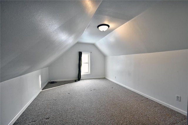 bonus room featuring vaulted ceiling, carpet floors, and a textured ceiling