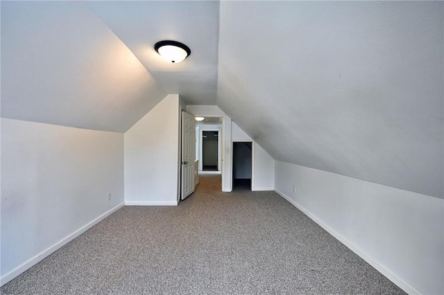 bonus room with vaulted ceiling and carpet flooring